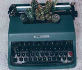 An old typewriter with cactuses growing inside